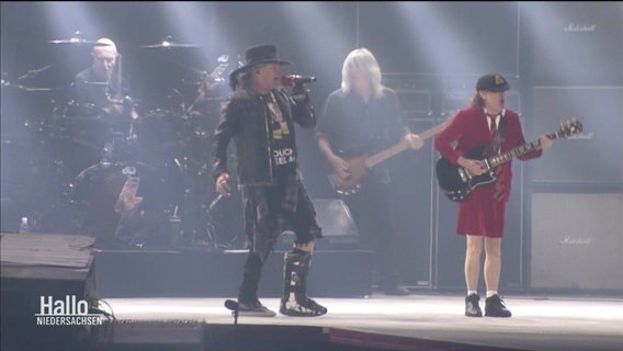 Musiker der Band AC/DC stehen auf einer Bühne. © Screenshot 
