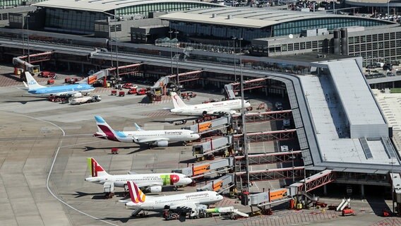 Blick aus der Luft auf mehrere Flugzeuge, die am Hamburg Airport abgefertigt werden. (Archivfoto) © picture alliance / dpa Foto: Axel Heimken