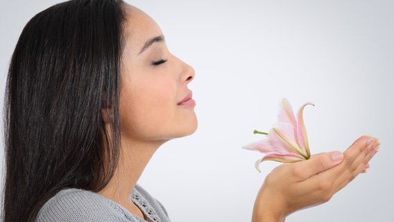 Frau inhaliert den Duft einer Lilie © colourbox Foto: -